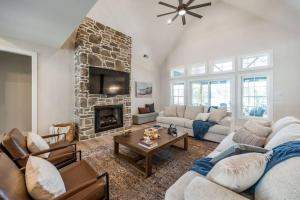een woonkamer met een bank en een open haard bij Bass Cove - Luxury Lakefront, Hot Tub, Fire Table & Theatre! in Kasey