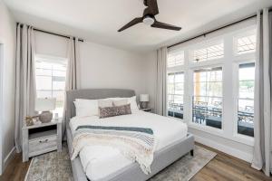 een witte slaapkamer met een bed en een plafondventilator bij Bass Cove - Luxury Lakefront, Hot Tub, Fire Table & Theatre! in Kasey