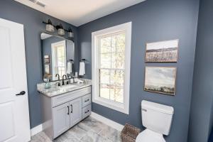 een blauwe badkamer met een toilet en een wastafel bij Bass Cove - Luxury Lakefront, Hot Tub, Fire Table & Theatre! in Kasey +88 foto's