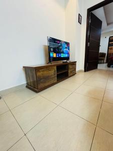 a living room with a flat screen tv on a table at Syed Apartment 104 in Islamabad
