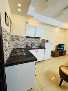 a kitchen with white cabinets and a counter top at Syed Apartment 104 in Islamabad