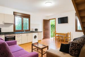 un soggiorno con un divano e un tavolo di Casa vacacional La Vicoca a Poo de Llanes