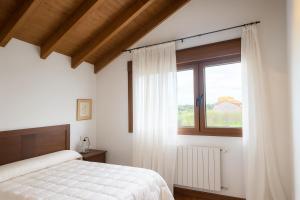 una camera da letto con un letto e una finestra di Casa vacacional La Vicoca a Poo de Llanes