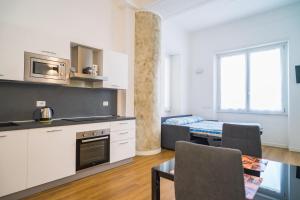 een keuken en woonkamer met een bank en een tafel bij P&P House 38 Bilo 2 in Bergamo