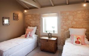 two twin beds in a room with a window at Kallista House in Kourtaíïka
