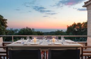 a table set for a meal on a balcony with a sunset at Kallista House in Kourtaíïka +25 photos