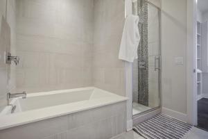 un bagno bianco con vasca e doccia di Midtown Penthouse 2 bdrm ad Atlanta Altre 17 foto