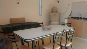 Cabañas el atardecer de Andrés - Flor Serrana - Tanti في تانتي: مطبخ مع طاولة بيضاء مع كراسي وكاونتر