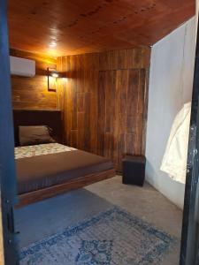Un dormitorio con una cama y una pared de madera. en Las cabañas duo, en Tulum