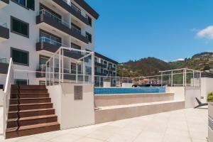een gebouw met een trap en een zwembad bij GuestReady - The perfect hideout in Caniço in Caniço