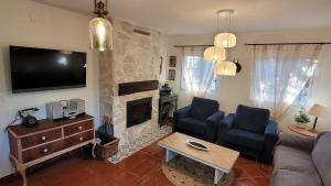 a living room with a couch and a fireplace at Cortijo Atalaya de Loaimes in Granada