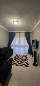 a living room with a couch and a rug at SBJ's Home in Entebbe