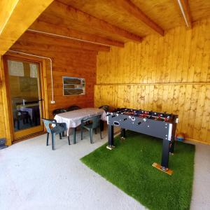 een kamer met een tafeltennistafel en stoelen bij Appartamenti Penasa Renato in Commezzadura