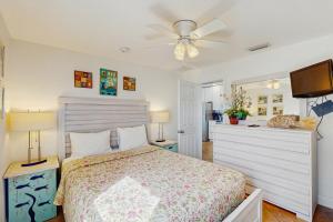 een slaapkamer met een bed en een plafondventilator bij Sea's The Day in Anna Maria +9 foto's