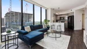 a living room with a blue couch and a kitchen at Amazing Midtown 2 bdrm in Atlanta