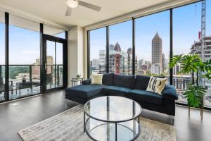 a living room with a blue couch and large windows at Amazing Midtown 2 bdrm in Atlanta