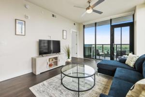 a living room with a blue couch and a tv at Amazing Midtown 2 bdrm in Atlanta