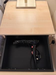 a drawer under a wooden table with a black cord at Comfortable double room with own bathroom in Inshes +6 photos