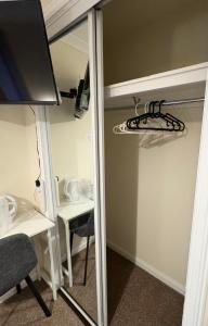 a mirror in a room with a table and a desk at Comfortable double room with own bathroom in Inshes
