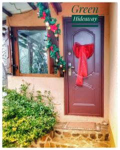 een rode deur met een rode strik erop bij Green Hideaway in Fîntînele