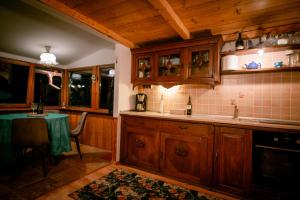een keuken met houten kasten en een tafel. bij Green Hideaway in Fîntînele