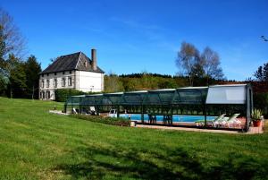 ein Gebäude mit einem Pool neben einem Haus in der Unterkunft Les Vergnes in Saint-Pardoux-le-Neuf