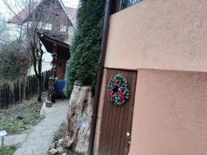 een deur met een krans aan de zijkant van een huis bij Green Hideaway in Fîntînele