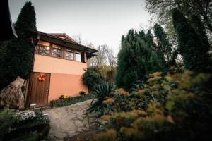 een huis met een houten deur in een tuin bij Green Hideaway in Fîntînele