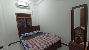 un dormitorio con una cama y un espejo en APV Home, en Trincomalee