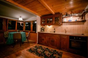 een keuken met een tafel met een groene tafelkleed bij Green Hideaway in Fîntînele +22 foto's