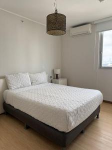 une chambre avec un lit dans une pièce blanche dans l'établissement Delightful Ocean View Apartment - PH Quartier Del Mar, à Panama City