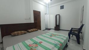 un dormitorio con una cama y una silla en APV Home, en Trincomalee