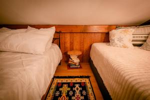 ein Schlafzimmer mit zwei Betten und einem Teppich auf dem Boden in der Unterkunft La Cascade - Casa de vacanta in Fîntînele + 41 Fotos