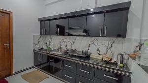 a kitchen with black cabinets and marble counter tops at APV Home in Trincomalee