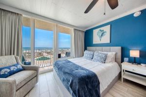 a bedroom with a bed and a couch and a window at EPIC Gulf & Beach Views with Balcony, Beach Supplies, & Pool in St. Pete Beach