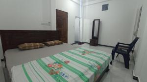un dormitorio con una cama y una silla en APV Home, en Trincomalee