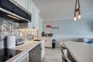 a kitchen with white cabinets and a counter top at EPIC Gulf & Beach Views with Balcony, Beach Supplies, & Pool in St. Pete Beach