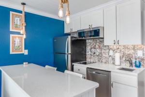 a kitchen with a blue wall and a refrigerator at EPIC Gulf & Beach Views with Balcony, Beach Supplies, & Pool in St. Pete Beach +26 photos
