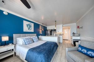 a bedroom with a bed and a couch and a kitchen at EPIC Gulf & Beach Views with Balcony, Beach Supplies, & Pool in St. Pete Beach