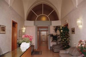 a hallway of a building with a lobby with flowers at Hotel Castello in Mesagne