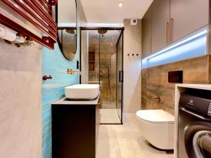 een badkamer met een toilet, een wastafel en een douche bij Mint Apartments Gdańsk DOKI in Gdańsk