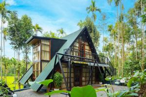 a house in a forest with a black roof at Ethnic Villa Wayanad in Kenichira