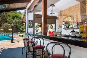 een bar met rode stoelen en een zwembad bij Achousa Hotel in Faliraki