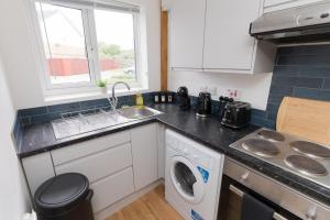 a kitchen with a sink and a washing machine at Contractors-Relocation-Free Parking-M5 Junction2 in Oldbury +18 photos