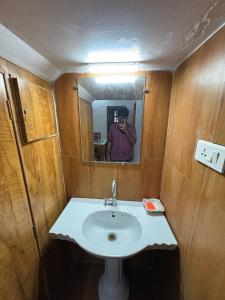 a person taking a picture of a sink in a bathroom at Sathya Holidays Evermist Stay in Ooty +10 photos