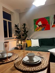 a living room with a table with plates and wine glasses at Liebe Wohnung Pension in Penig