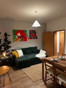 a living room with a green couch and a table at Liebe Wohnung Pension in Penig