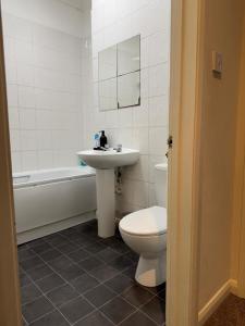 een badkamer met een wastafel, een toilet en een bad bij Smart Junction in Norwood