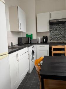 een keuken met witte kasten en een wasmachine bij Smart Junction in Norwood +22 foto's