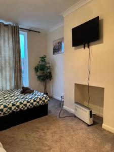een slaapkamer met een bed en een flatscreen-tv bij Smart Junction in Norwood